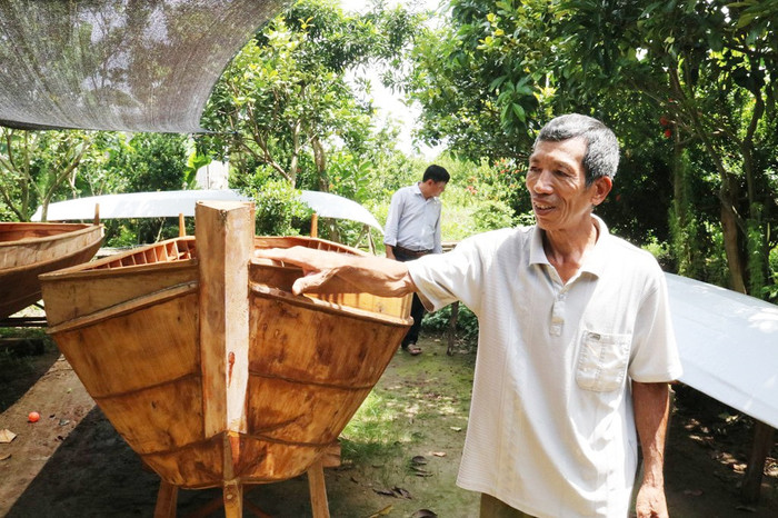 Trong ảnh là Nguyễn Văn Tốt (63 tuổi, xã Long Hậu) có hơn 40 năm gắn bó với nghề đóng ghe, xuồng, nhưng đến năm 2008, ông Tốt đành 'bẻ lái' sang nghề đóng ghe, xuồng thu nhỏ mưu sinh hơn 15 năm qua. Ảnh: Đại biểu Nhân dân