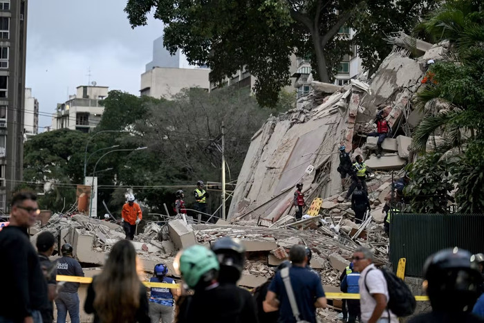 Các nhân viên cứu hộ đang làm việc tại hiện trường một tòa nhà bị sập ở Caracas vào thứ Tư.Juan Barreto / AFP qua Getty Images.