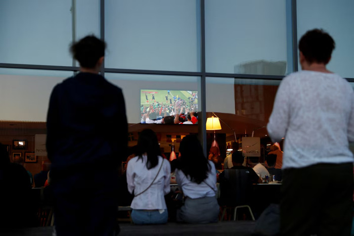 Người đi đường theo dõi màn hình TV tại khách sạn Novotel Wembley trong thời gian thi đấu hiệp phụ, khi các cầu thủ Croatia ăn mừng bàn thắng thứ hai. Bóng đá, World Cup, người hâm mộ Anh theo dõi trận Croatia gặp Anh tại Wembley, London, Vương quốc Anh - ngày 11/7/2018. Ảnh: Reuters