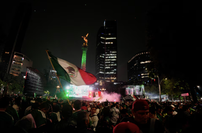 Người hâm mộ đội tuyển Mexico ăn mừng gần Đài tưởng niệm Thiên thần Độc lập (Angel of Independence) sau khi đội nhà giành chiến thắng. Ảnh: Armando Vega/Reuters.