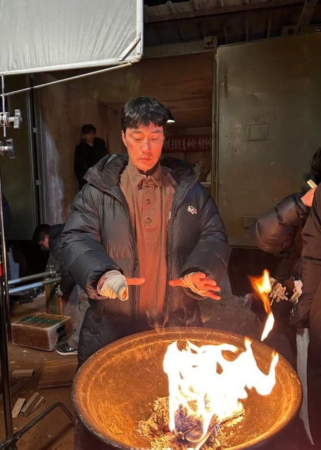 So Ji Sub sưởi ấm ở hậu trường phim.