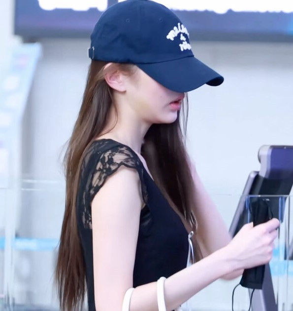 Jang Won Young đội mũ lưỡi trai kín đáo trong lúc làm thủ tục xuất nhập cảnh.