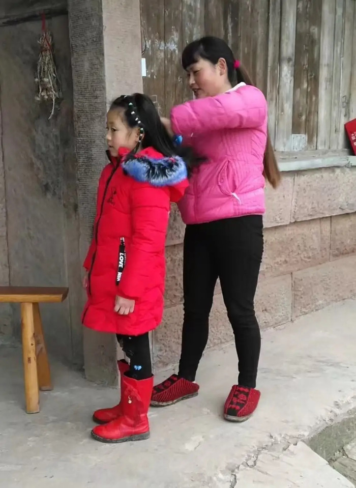 Dì Yi, người hàng xóm, chải tóc cho Trương Chính. (Ảnh do người được phỏng vấn cung cấp)