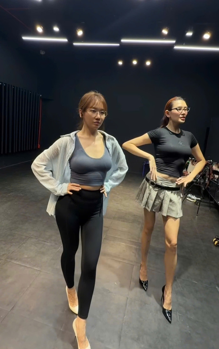 Hari Won diện trang phục tập luyện, chăm chú thực hiện những bước catwalk trong không gian phòng tập. Ảnh chụp màn hình FBNV&nbsp;