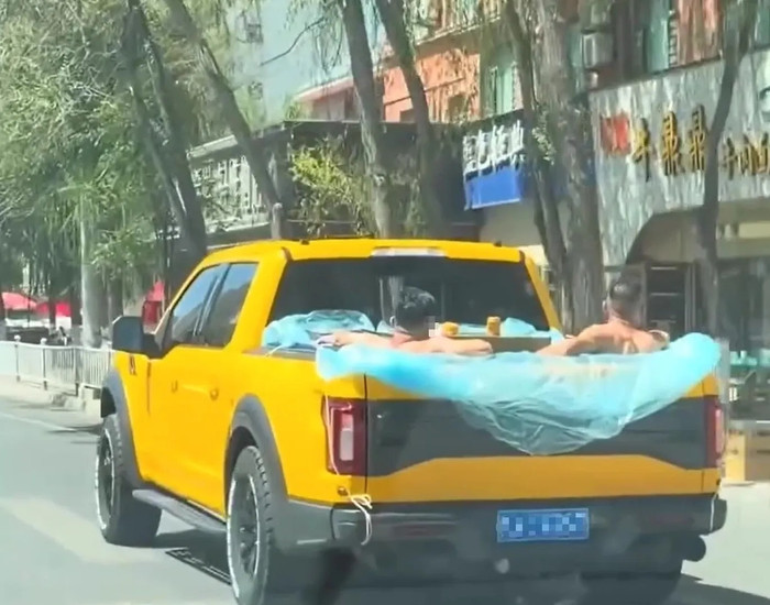 Hai người bạn được nhìn thấy đang uống rượu trong khoang chung của thùng xe bán tải. Ảnh: Jam Press