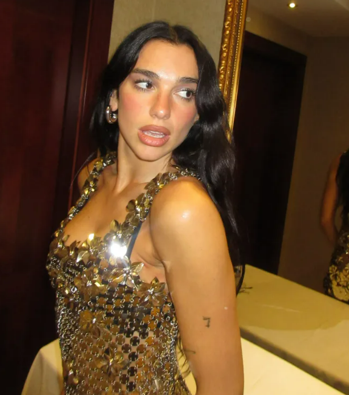 Dua Lipa lựa chọn chiếc váy mini bằng chất liệu xích kim loại màu vàng ánh kim. Ảnh: IGNV