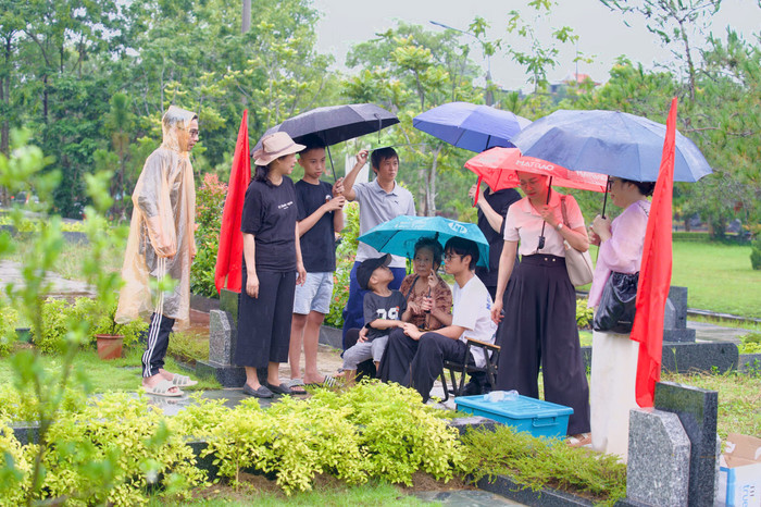 Dù trời mưa, các con cháu vẫn cùng bà Lịch đi thăm viếng tổ tiên.