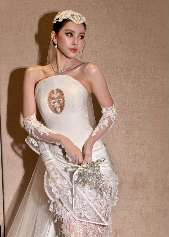 Tiểu Vy hóa cô dâu trong bộ váy cưới trắng, khoe nhan sắc thanh tú cùng thần thái sang trọng.