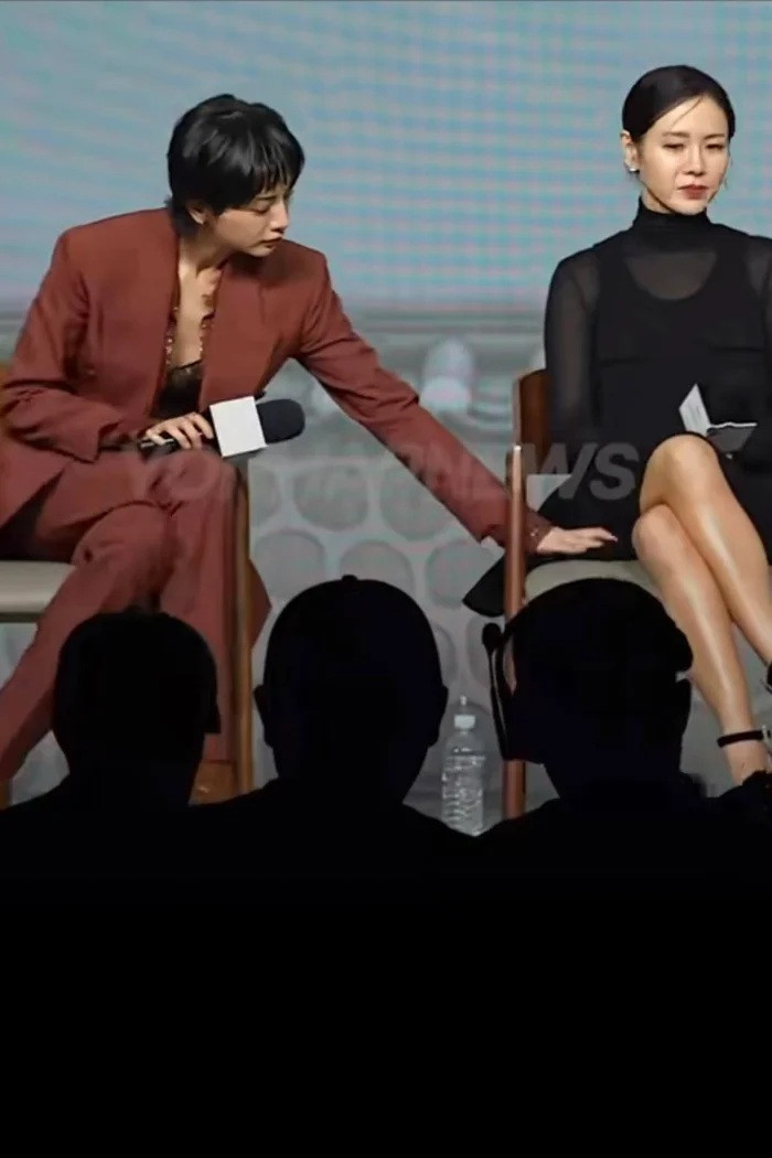 Son Ye Jin gặp sự cố với chiếc váy ở họp báo. Diễn viên Nana tinh ý chỉnh giúp đàn chị trong nghề. (Ảnh từ Yonhap News)