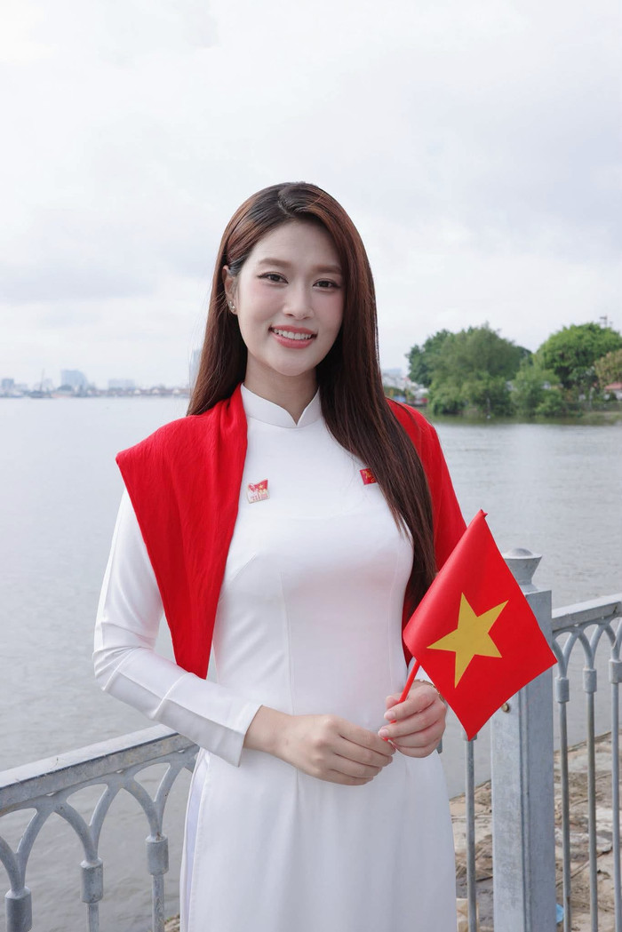 Đoàn Thiên Ân hòa cùng không khí đặc biệt của ngày lễ 2/9. Nàng hậu đăng ảnh mặc áo dài trắng, cầm lá cờ đỏ sao vàng đầy tự hào.