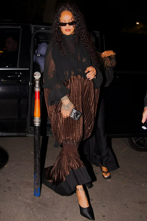 Rihanna thay đổi trang phục, diện váy Ferragamo xếp ly ánh kim khi xuất hiện tại một nhà hàng. Ảnh: BACKGRID
