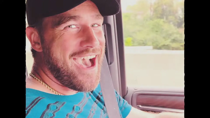 Travis Kelce xuất hiện với nụ cười rạng rỡ trước ống kính khi đang lái xe.