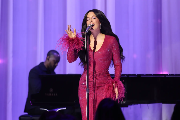 Kacey Musgraves xuất hiện trên sân khấu trong chiếc váy sequin màu hồng nổi bật với phần tay áo đính lông vũ.&nbsp;