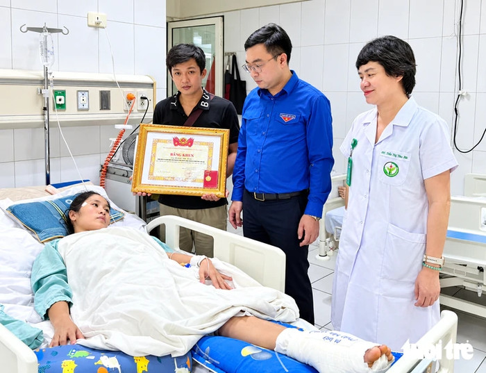 Thừa ủy quyền của Ban Bí thư Trung ương Đoàn, anh Hồ Phúc Hải - Bí thư Tỉnh Đoàn Nghệ An - đã tới Bệnh viện Việt Đức (Hà Nội) trao bằng khen của Ban Chấp hành Trung ương Đoàn và huy hiệu 'Tuổi trẻ dũng cảm' cho cô Hoàng Thị Hiền - Ảnh: TÂM PHẠM&nbsp;