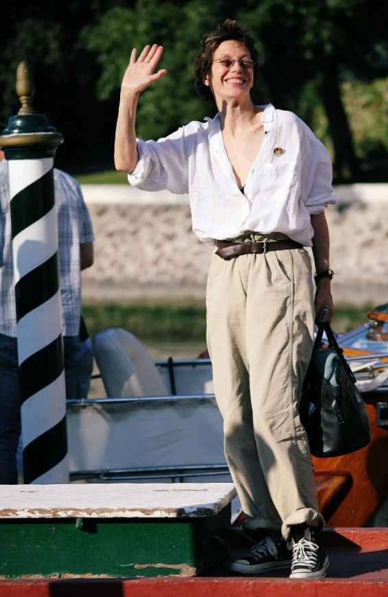 Jane Birkin tiếp tục khẳng định phong cách thời trang phóng khoáng khi xuất hiện tại liên hoan phim năm 2009. Cô diện sơ mi linen trắng oversized cùng quần công sở rộng được xắn gấu, kết hợp thắt lưng tạo điểm nhấn ở eo và giày Converse cổ cao. Cách phối đồ đơn giản nhưng đầy cá tính gợi nhớ hình ảnh kinh điển của các quảng cáo Armani. Ảnh: Getty Images