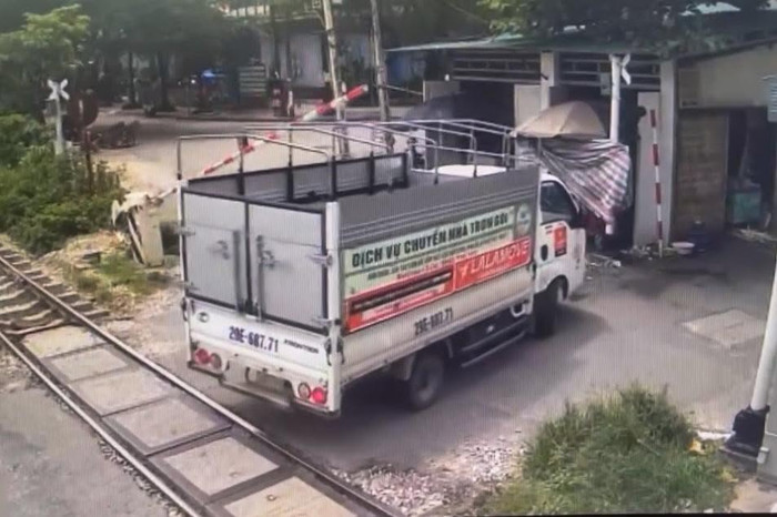 Xe tải lùi tại đường ngang làm hỏng cần chắn. Ảnh: Công an TP Hà Nội&nbsp;