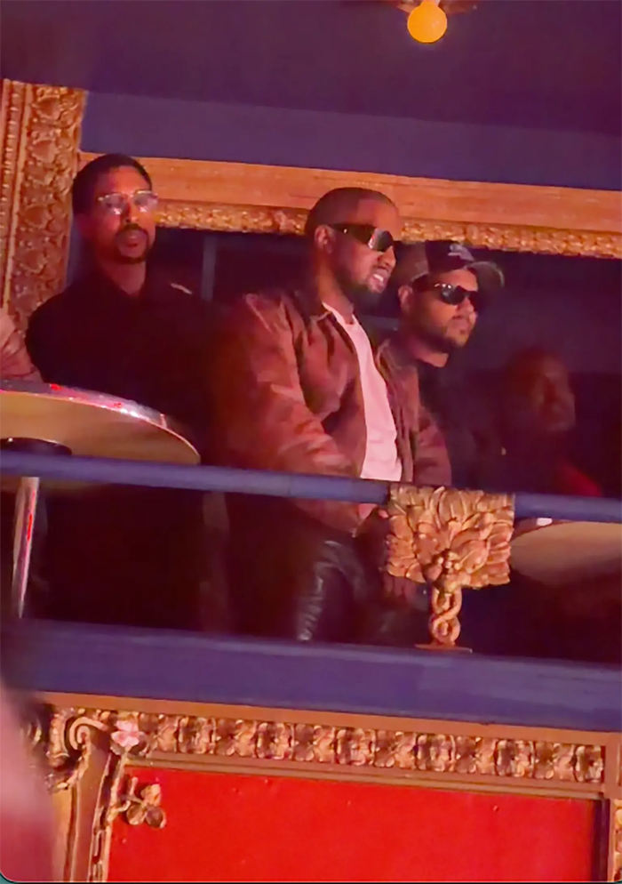 Nam rapper chăm chú theo dõi North từ một ban công cùng ê-kíp của mình.