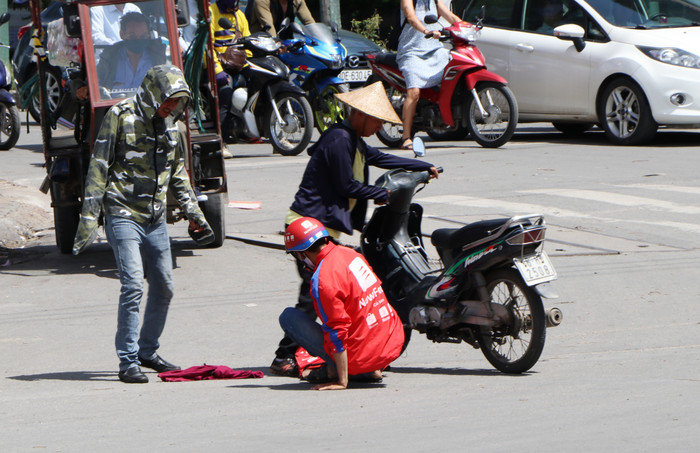 Có tài xế bị ngã ra đường vì nắng nóng được mọi người đỡ dậy.