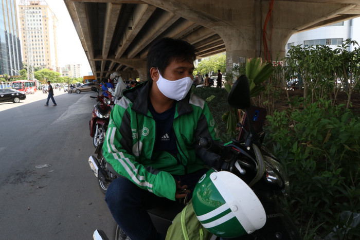 Anh Thưởng ngồi mệt nhoài sau chuyến chở khách từ Long Biên sang Mỹ Đình.