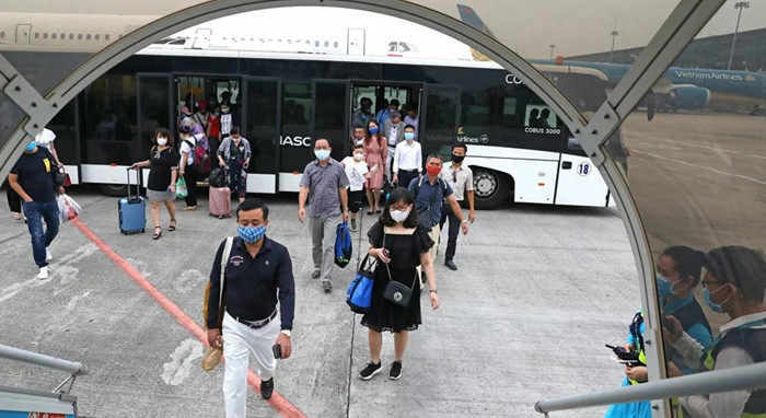 Hành khách bắt buộc phải đo thân nhiệt và khai báo y tế trước khi lên máy bay. Ảnh: TTXVN