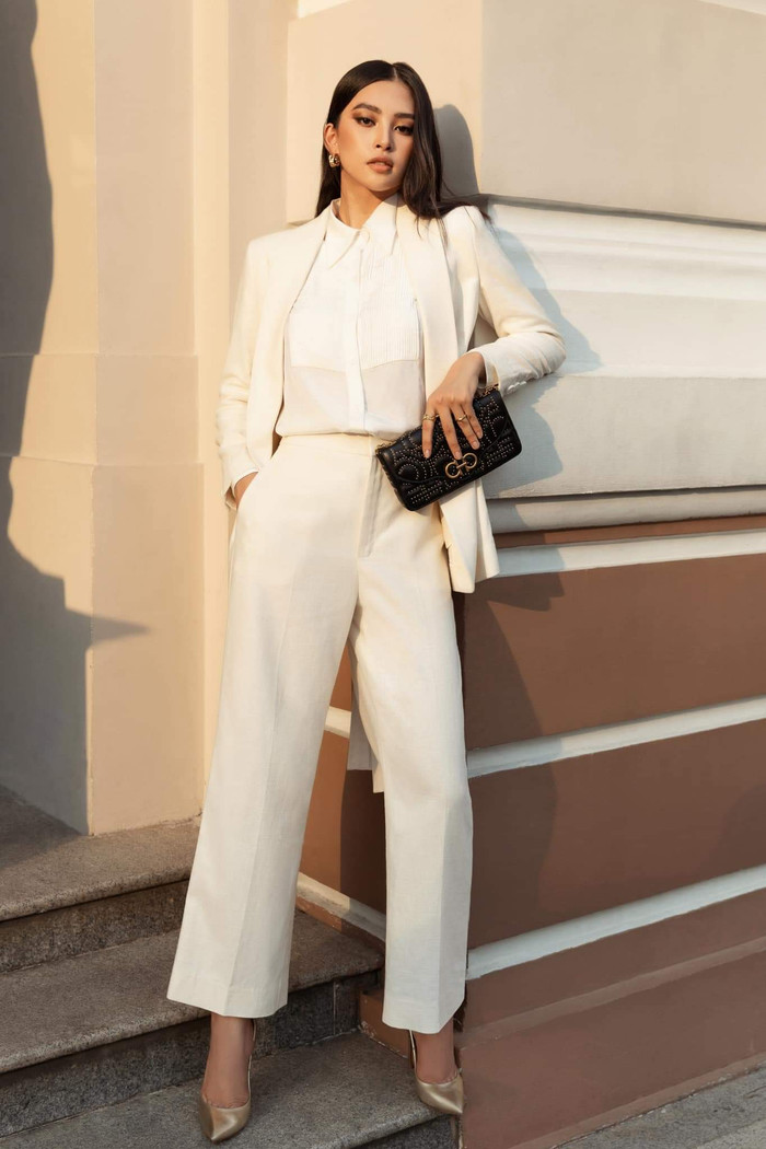 Hoa hậu Tiểu Vy khoe vẻ đẹp thanh lịch trong cả cây suit trắng của NTK Công Trí. Đối lập với màu sắc trang phục là chiếc túi cầm tay đen tạo thành điểm nhấn. 