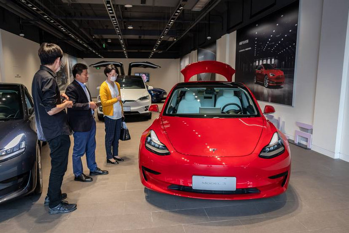 Khách hàng ở Thượng Hải đang kiểm tra một chiếc xe Tesla Model 3 hồi tháng 5. Ảnh: Getty
