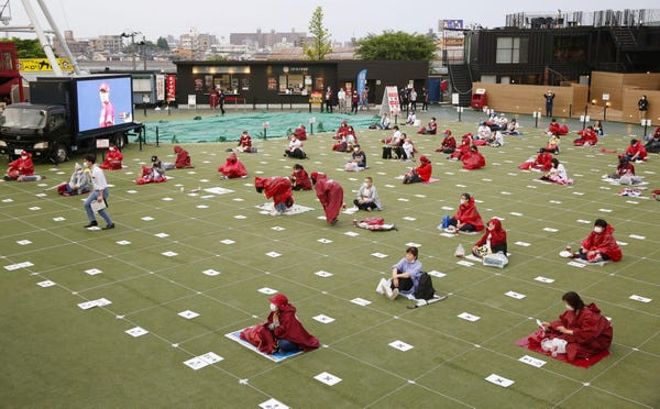 Cùng thời điểm, người hâm mộ của Rakuten Eagles, đội bóng đối thủ, xem trận đấu qua màn hình lớn nhưng vẫn duy trì giãn cách xã hội. Ảnh: Getty