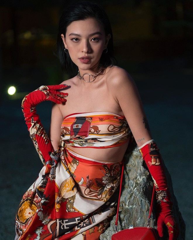 Dùng khăn làm áo đã quá quen thuộc, Tú Hảo nay chơi lớn hơn khi dùng khăn làm luôn chân váy. Nữ người mẫu trang điểm tông nude sắc sảo, đeo vòng cổ kim loại cá tính và găng tay vải nhằm đồng điệu cùng trang phục.