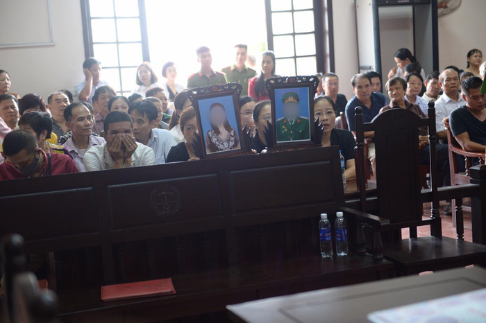 Người thân mang di ảnh nạn nhân đến toà.