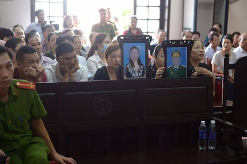 Người thân mang di ảnh nạn nhân đến toà.