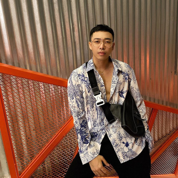 Stylist Hoàng Ku tiếp tục chứng tỏ độ chịu chơi xem lẫn chịu chi khi trưng trổ áo sơ-mi hoạ tiết cùng túi yên ngựa đắt giá của nhà mốt Dior. 