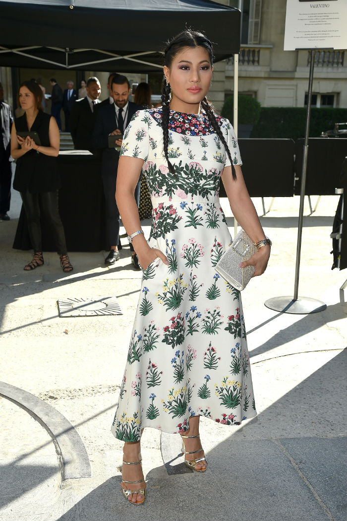 Diện nguyên bộ váy rực rỡ hoa lá mùa hè, thắt bím tóc hai tại show của Valentino vào năm 2016
