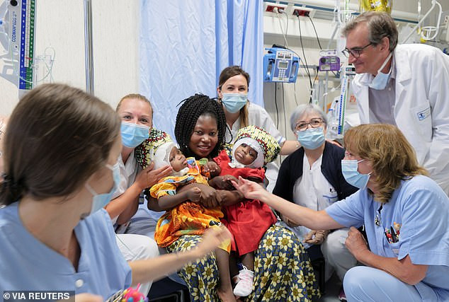 Mẹ con Nzotto bên đội ngũ y bác sĩ.