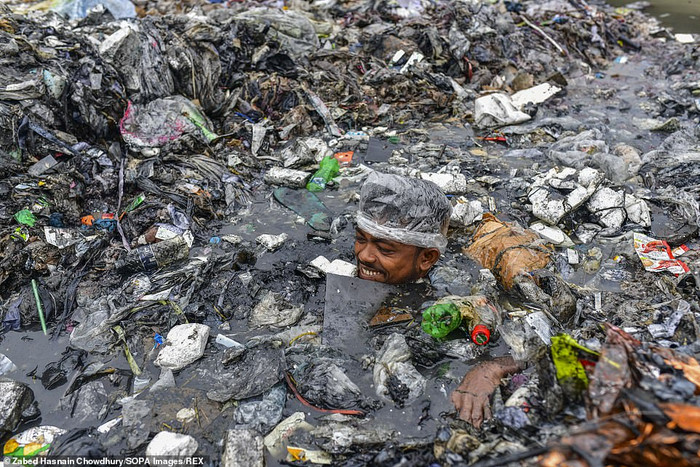 Một người đàn ông bơi sâu vào núi rác thải đô thị đã biến một phần kênh đào thành một khối.