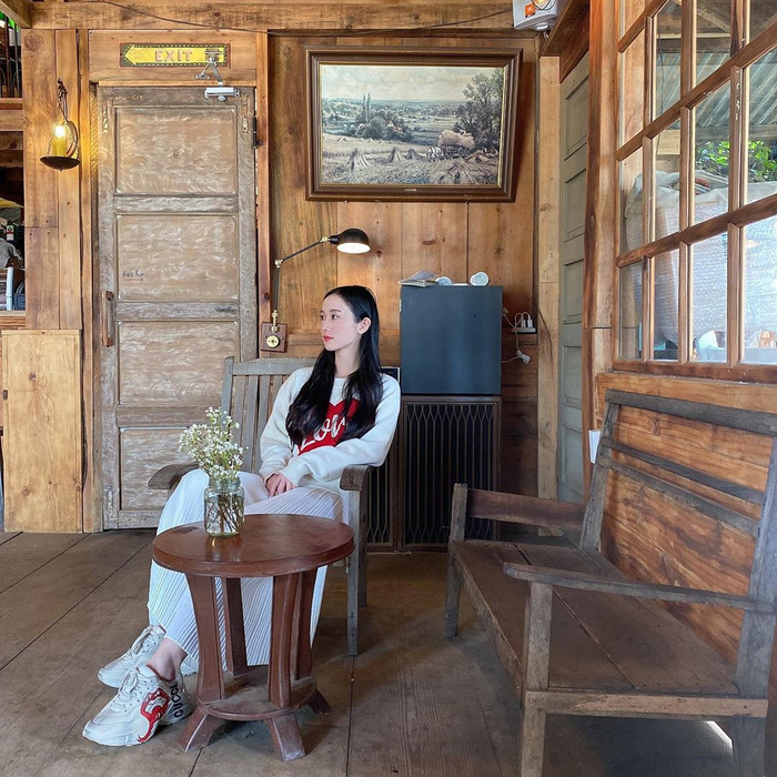 Jun Vũ mix áo hoodie với chân váy xếp ly trắng cùng giày thể thao hầm hố khi cô có chuyến du lịch đến Đà Lạt không lâu 