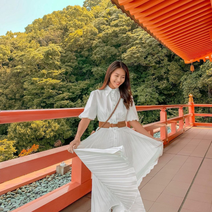 Khả Ngân lại vô cùng trẻ trung, năng động và cũng không kém phần sang trọng khi chọn áo sơ mi trắng mix cùng chân váy xếp ly tung xòe nhấn nhá phần belt thắt lưng màu nâu da bò 