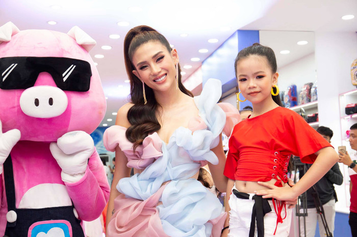 Người đẹp vui vẻ tạo dáng cùng một fan nhí. 