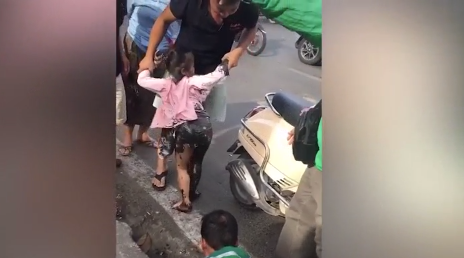 Bé gái người lấm lem bùn đất khi được giải cứu lên. 