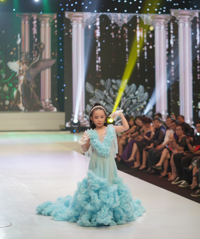 Tại đêm thời trang của NTK Phương Hồ, siêu mẫu nhí xuất hiện với chiếc đầm màu xanh được thiết kế bồng bềnh như một đám mây với chiều dài hơn 2 mét.