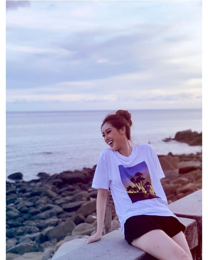 Hoa hậu Khánh Vân tươi tắn chụp ảnh bên bờ biển vắng.