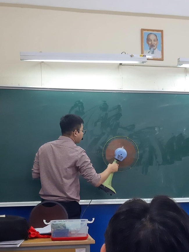Bảng vừa lau chưa kịp khô, thầy giáo chẳng để học trò phải chờ đợi, liền cầm thẳng quạt cho nhanh khô.
