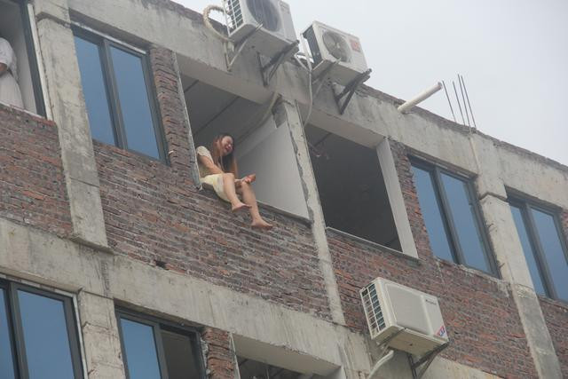 Người phụ nữ cầm dao ngồi trên bệ cửa sổ tầng 4 định tự tử. 