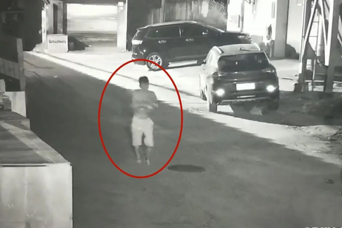 Người đàn ông bế đứa trẻ đi vứt ở bãi rác.