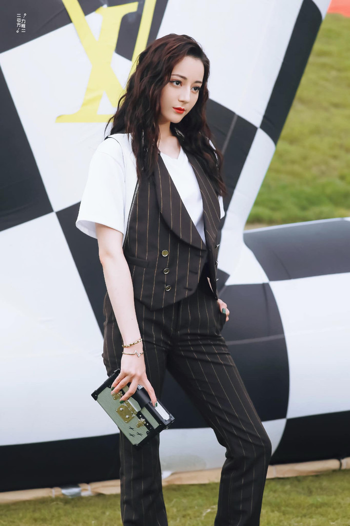 Mỹ nhân Tân Cương xuất hiện nổi bật với style tomboy khi mix trang phục áo thun trắng bên trong với áo gile kẻ sọc và quần tây&nbsp;