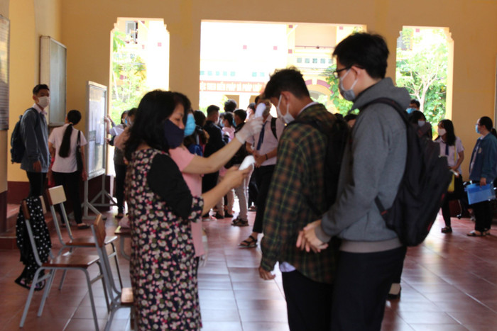 Giảng viên thực hiện công tác đo thân nhiệt