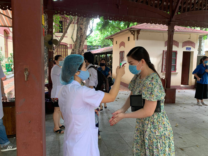 Cán bộ, nhân viên y tế đo thân nhiệt cho giảng viên