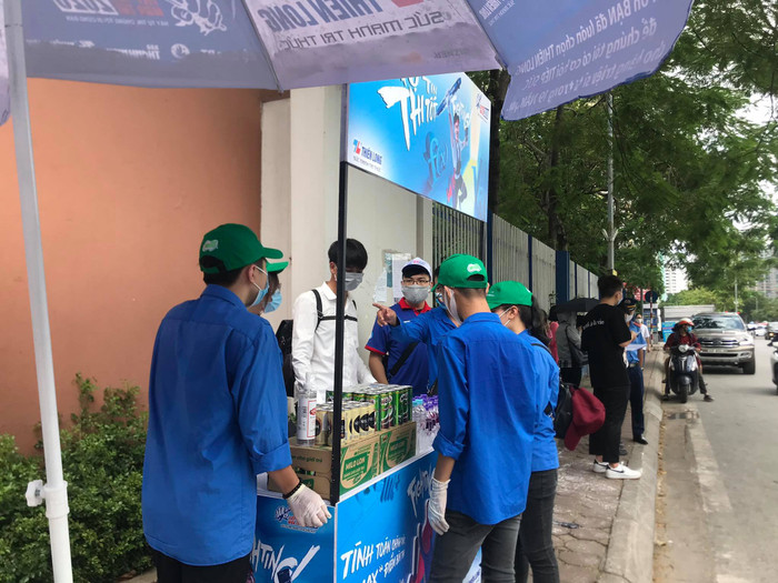 Đội thanh niên tình nguyện đứng trước cổng trường sẵn sàng công tác giúp đỡ các thí sinh dự thi
