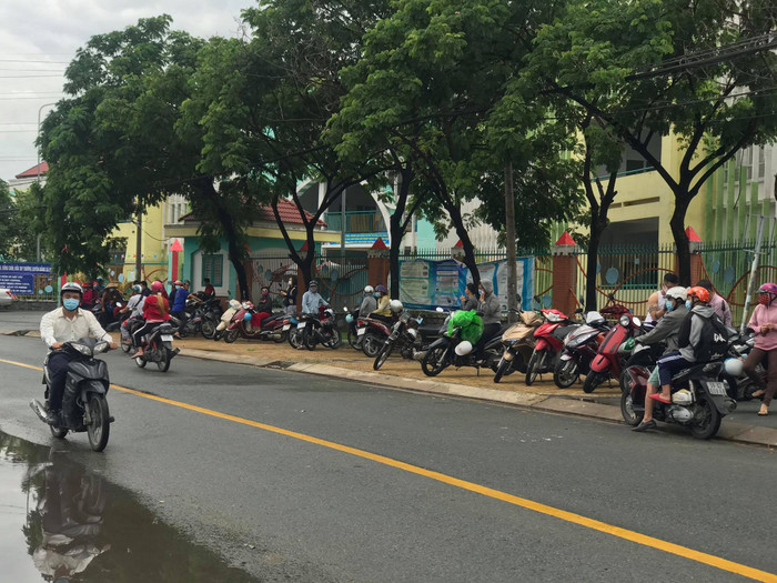 Trong lúc đợi các em làm thủ tục dự thi, các bậc phụ huynh đứng đợi bên ngoài công trường