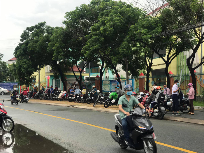 Nhiều phụ huynh đưa đón và chờ đợi con cái bên đường. 