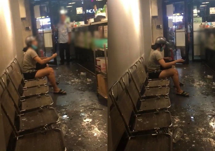 Người phụ nữ đập vỡ ly trà sữa làm nước bắn tung tóe trên sàn nhà.